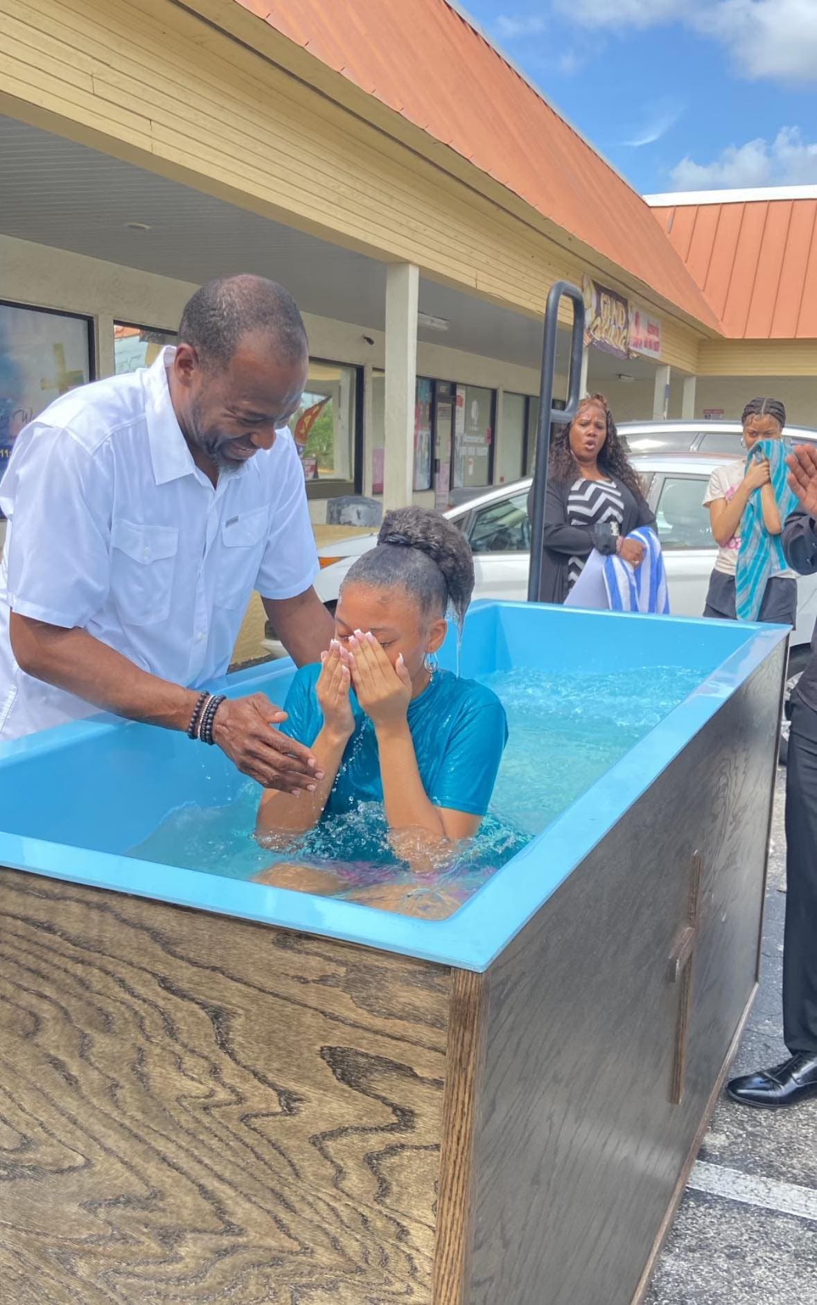 A baptism outside See His Face Ministries, with the church entrance behind
