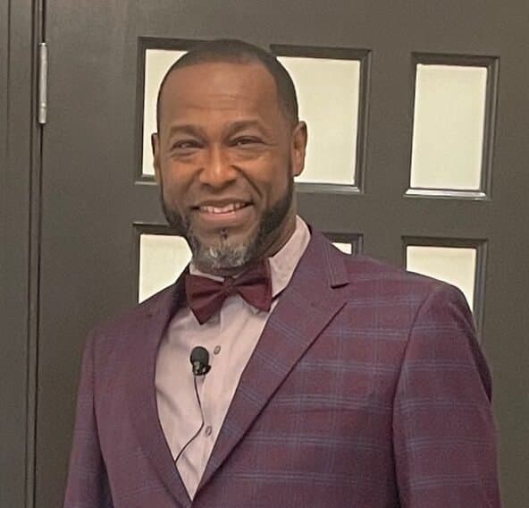 A man in a suit photographed indoors at See His Face Ministries